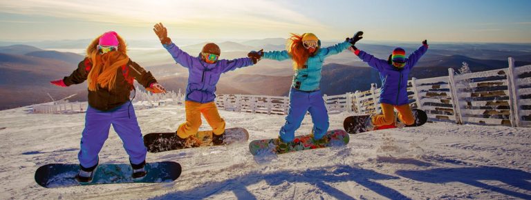 group of girls jumping on snowboards